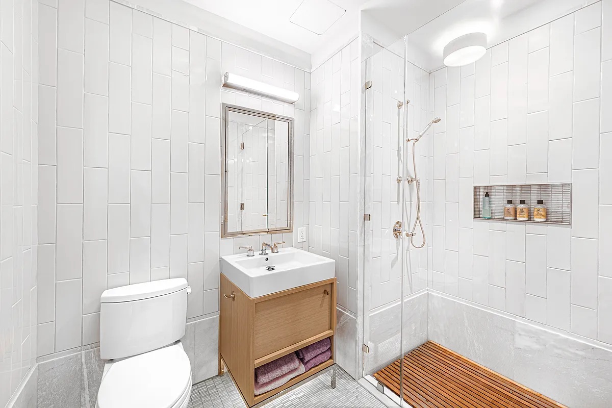 301 East 50th Street, Unit 4B Manhattan, NY 10022 - Photo 7 of 13 a bathroom with a sink a toilet and shower