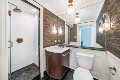 a bathroom with a toilet sink and mirror