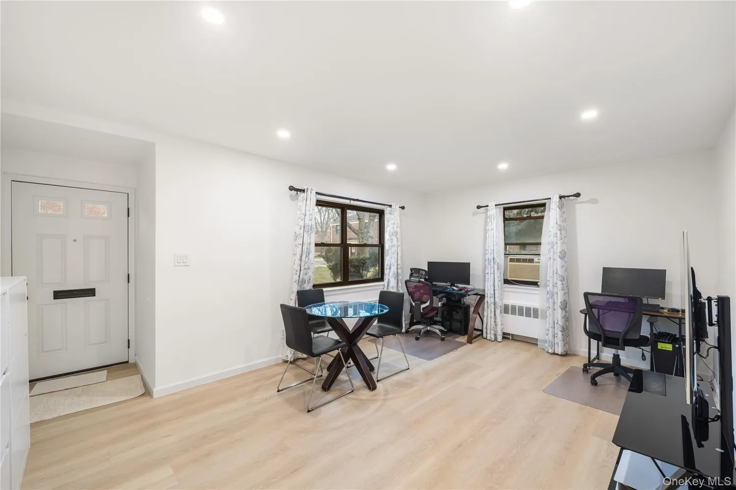 a view of a workspace with furniture and a window