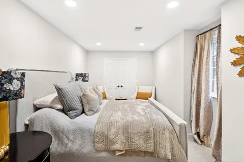 a bed room with two bed and a chair