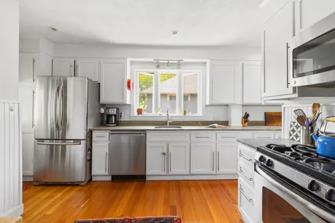 a kitchen with a refrigerator stove and white cabinets