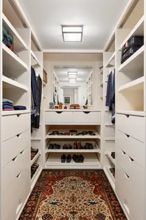 a view of walk in closet with clothes and shoes