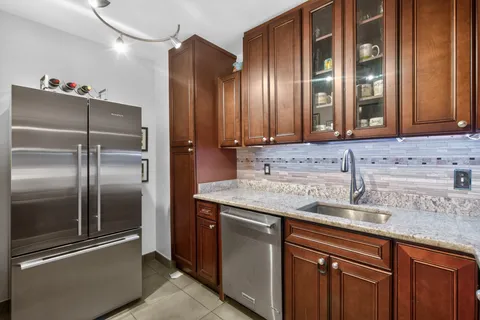 a kitchen with stainless steel appliances granite countertop a sink and a refrigerator