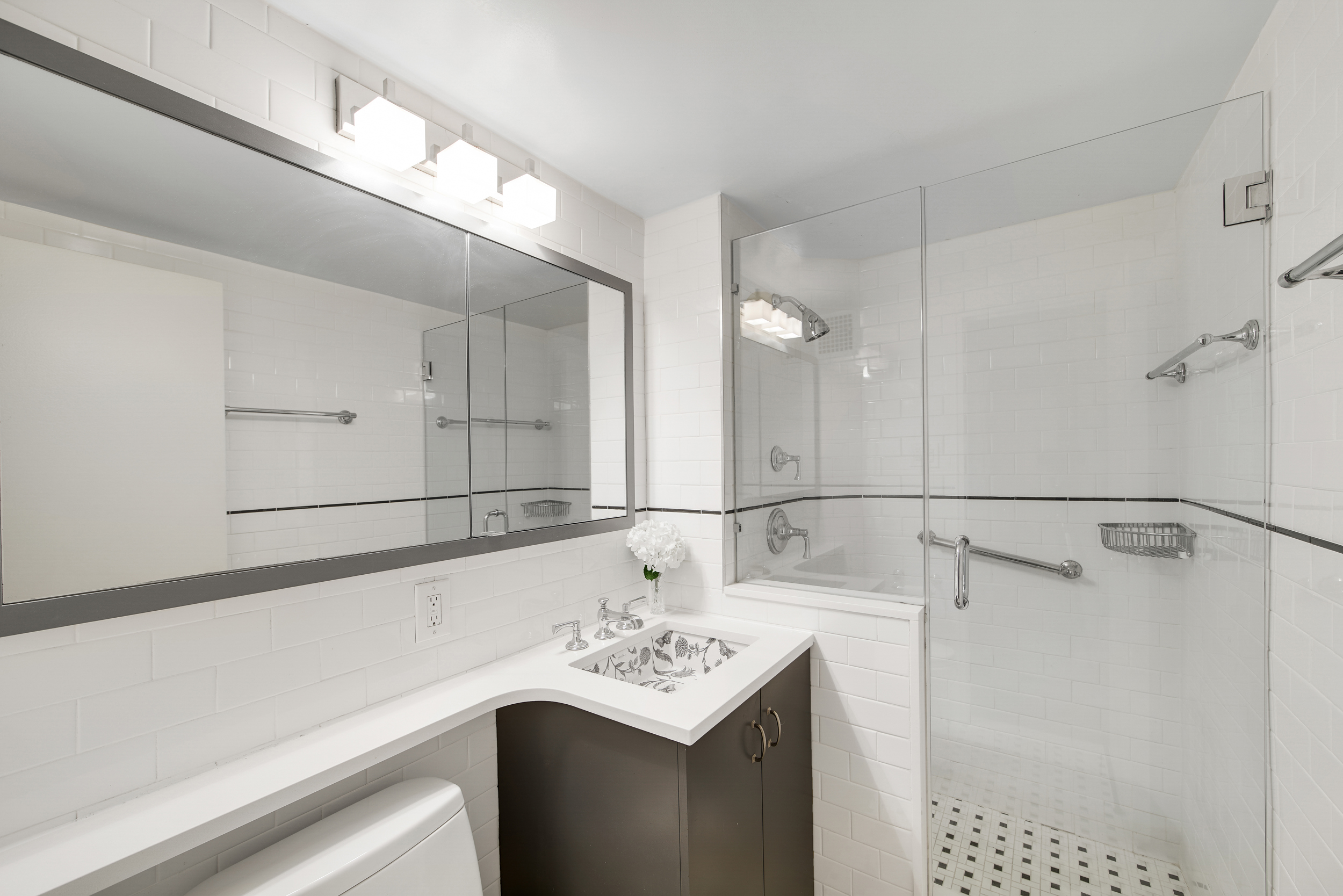 401 East 65th Street, Unit 16C Manhattan, NY 10065 - Photo 9 of 13 a bathroom with a sink vanity and a shower