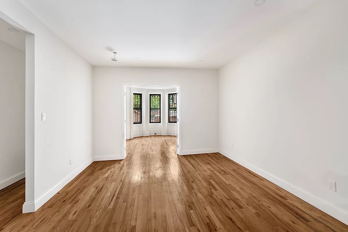 1097 Park Place, Unit 1 Brooklyn, NY 11213 - Photo 3 of 9 an empty room with wooden floor and windows