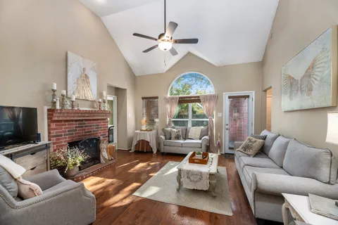 a living room with furniture a fireplace and a large window