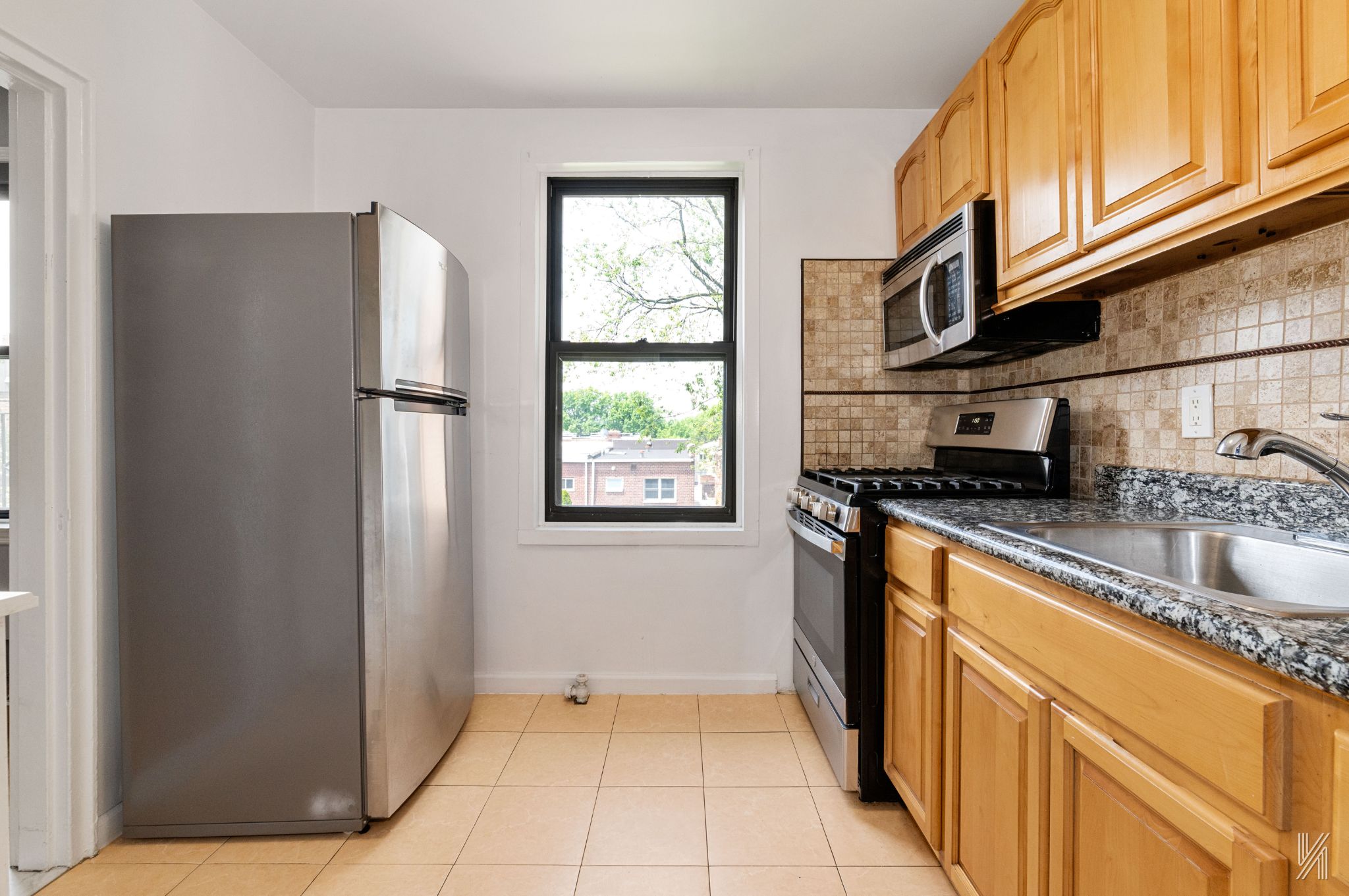 22-20 76th Street, Unit C3 Queens, NY 11370 - Photo 12 of 20 a kitchen with stainless steel appliances granite countertop a refrigerator and a sink