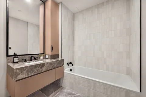 a bathroom with a granite countertop sink and a bathtub