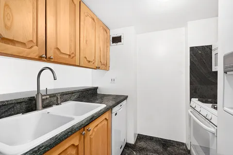 a bathroom with a granite countertop sink and a bathtub