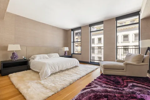 a spacious bedroom with a bed window and couch