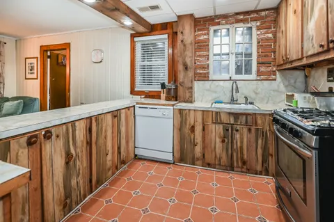 a kitchen with stainless steel appliances a sink stove and cabinets