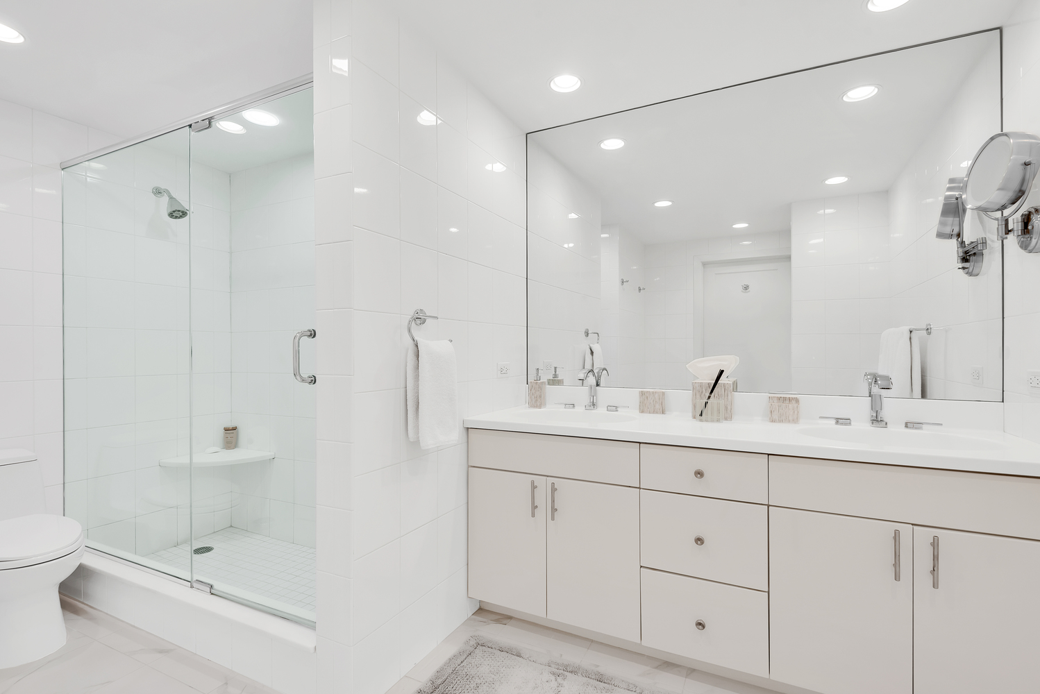 150 East 69th Street, Unit 8J Manhattan, NY 10021 - Photo 8 of 13 a bathroom with a double vanity sink mirror and shower