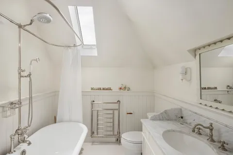 a bathroom with a granite countertop toilet sink and mirror