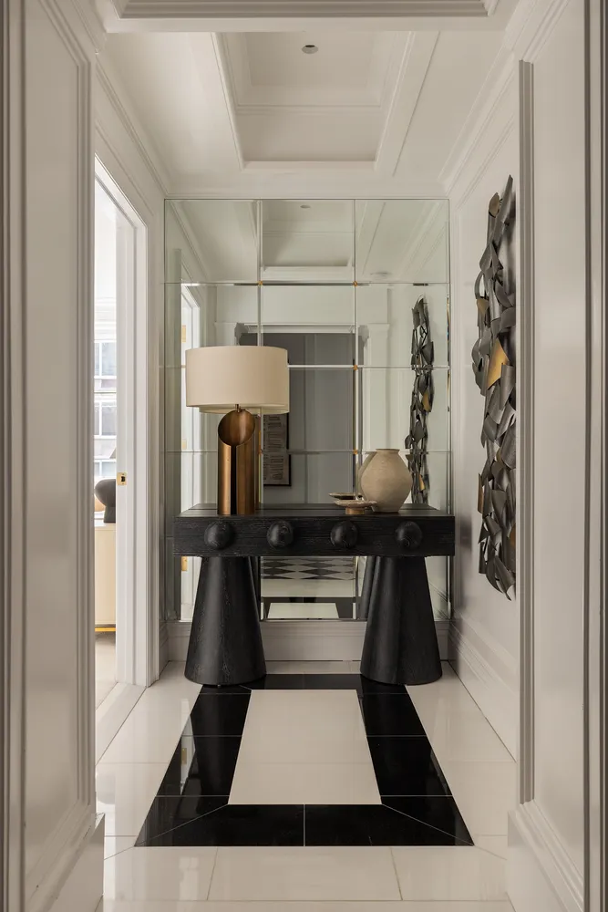 a hallway with white cabinets and stainless steel appliances
