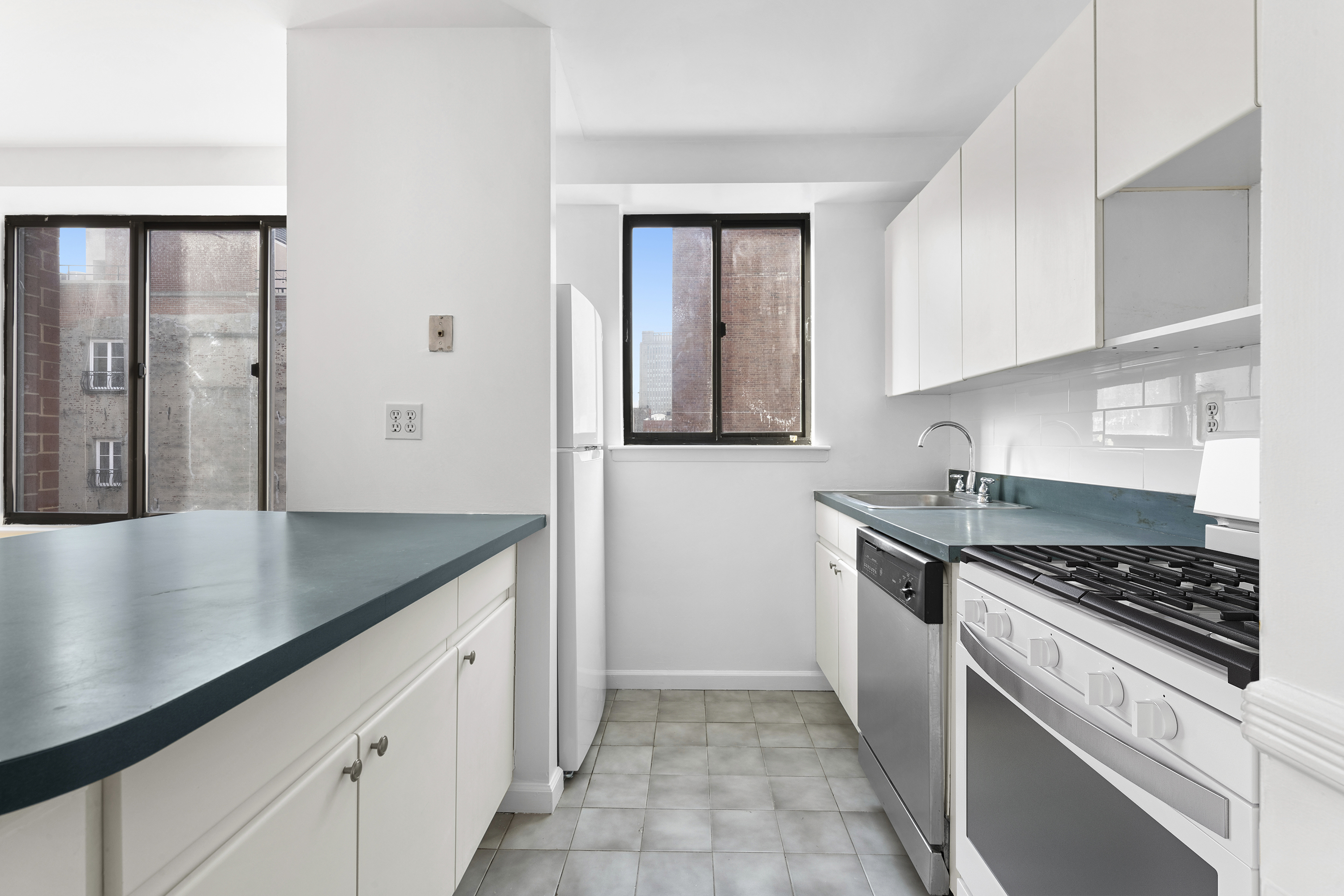 179 Grand Street, Unit 6G Manhattan, NY 10013 - Photo 4 of 8 a kitchen with stainless steel appliances granite countertop a sink stove and refrigerator