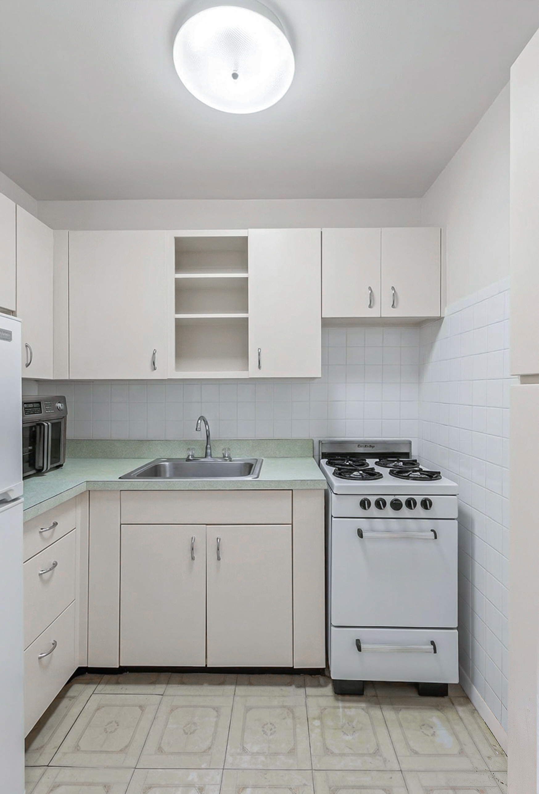 185 Hall Street, Unit 1514 Brooklyn, NY 11205 - Photo 4 of 13 a kitchen with granite countertop a stove sink and cabinets