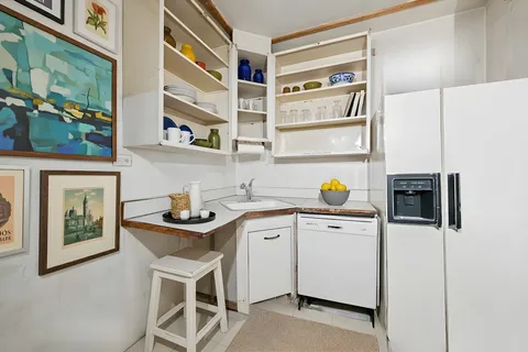 a utility room with stainless steel appliances lots of counter top space and wooden floor