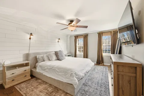 a bedroom with a large bed and a flat tv screen on dresser