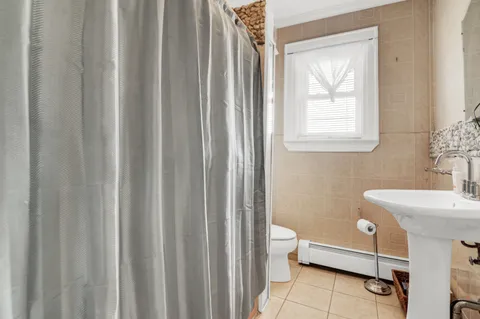 a bathroom with a sink a toilet and a window