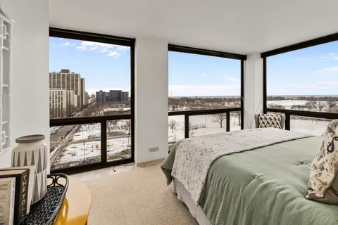 a bedroom with a large window and a bed