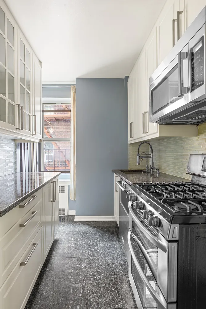 a kitchen with granite countertop a stove and a sink