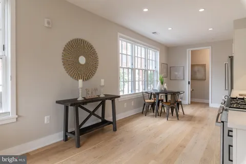 a view of a a dining room with furniture window and wooden floor