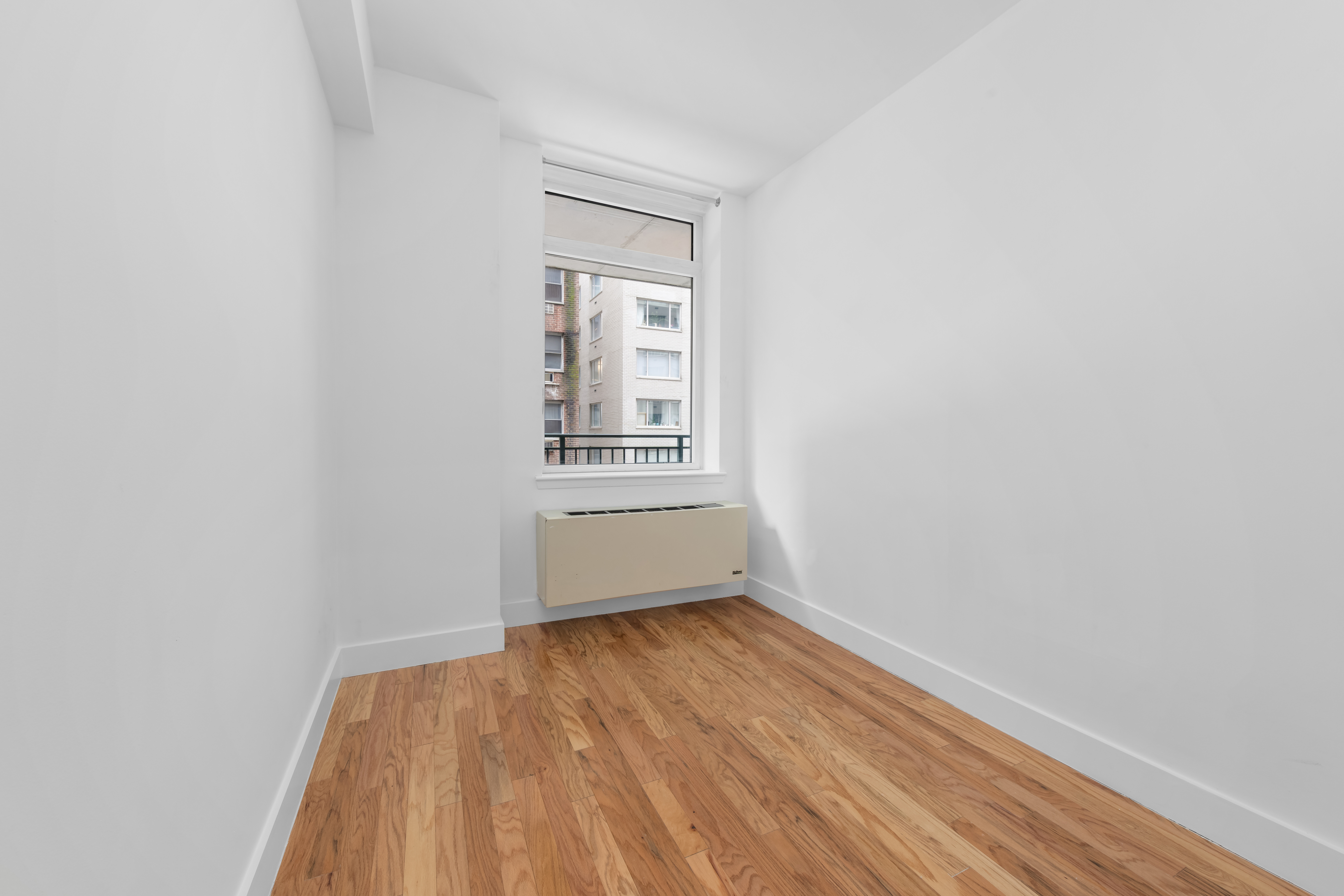 212 East 57th Street, Unit 3B Manhattan, NY 10022 - Photo 7 of 17 a view of an empty room with wooden floor and a window