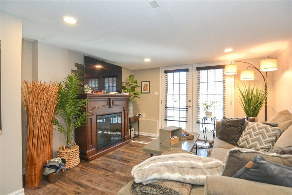 187 Blackstone Street Mendon, MA 01756 - Photo 31 of 42 a living room with furniture a fireplace and a floor to ceiling window