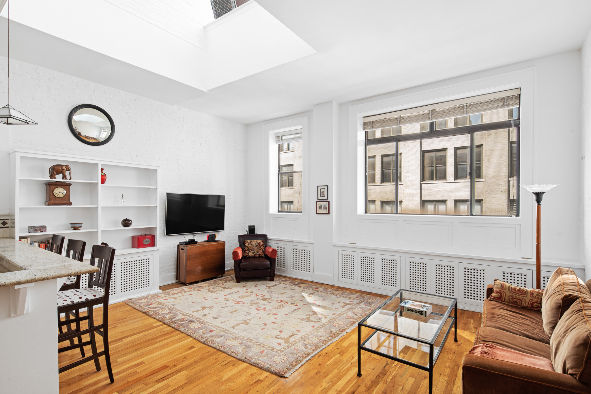 23 East 10th Street, Unit 5A/6A Manhattan, NY 10003 - Photo 3 of 12 a living room with furniture and a flat screen tv