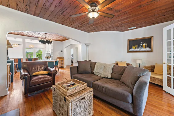 a living room with furniture a wooden floor and a ceiling fan