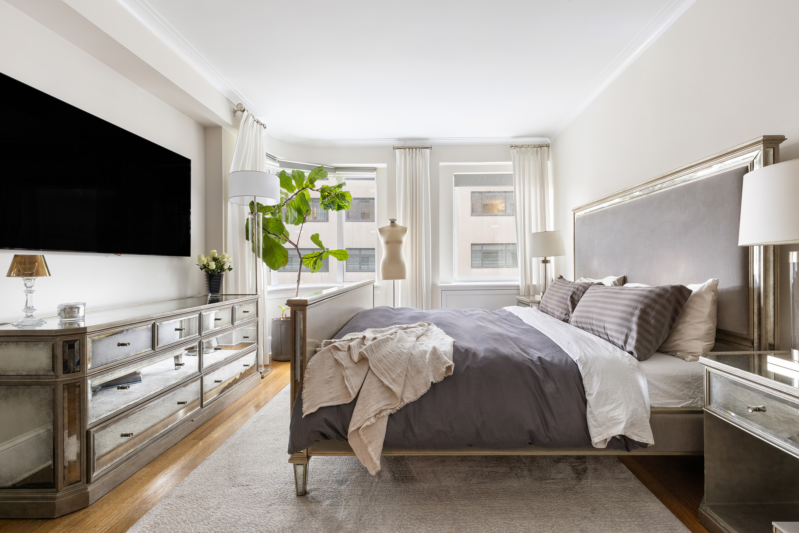 530 Park Avenue, Unit 14D Manhattan, NY 10065 - Photo 4 of 12 a bedroom with a bed and a flat tv screen on dresser