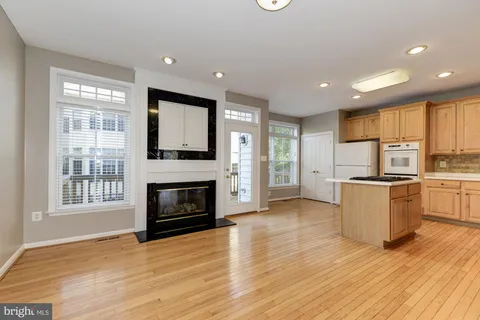 a view of kitchen with granite countertop stove top oven and refrigerator