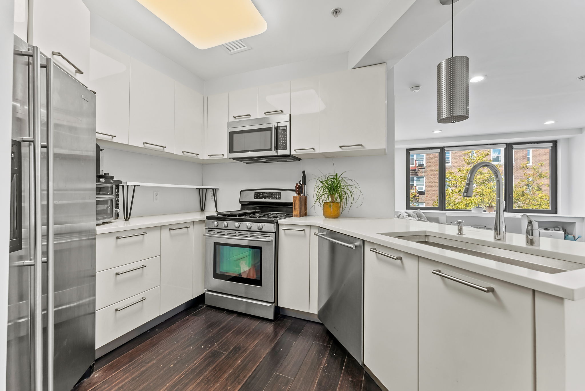 64-05 Yellowstone Boulevard, Unit 414 Queens, NY 11375 - Photo 2 of 14 a kitchen with cabinets stainless steel appliances a sink and a window