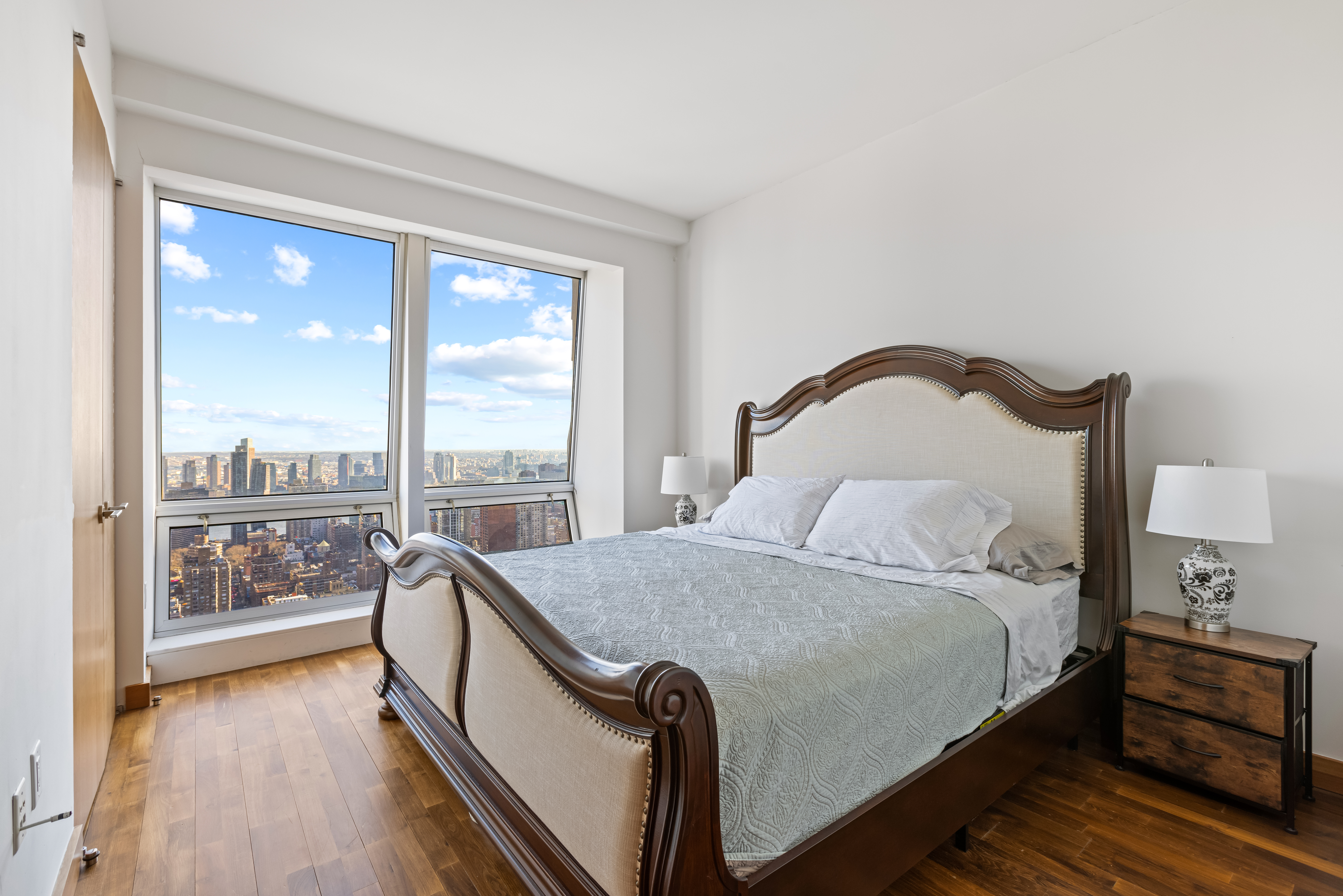 400 5th Avenue, Unit 49C Manhattan, NY 10018 - Photo 8 of 21 a bedroom with a bed and a large window with outer view