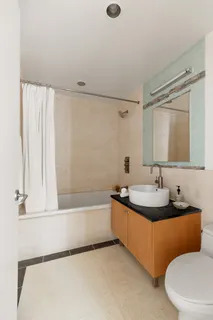 a bathroom with a double vanity sink toilet mirror and bathtub