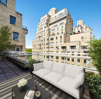 a view of a balcony with chairs and a potted plant