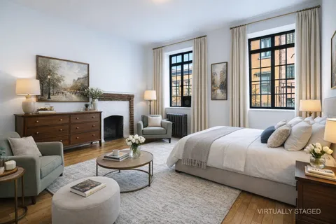 a bedroom with a bed couches and a fireplace