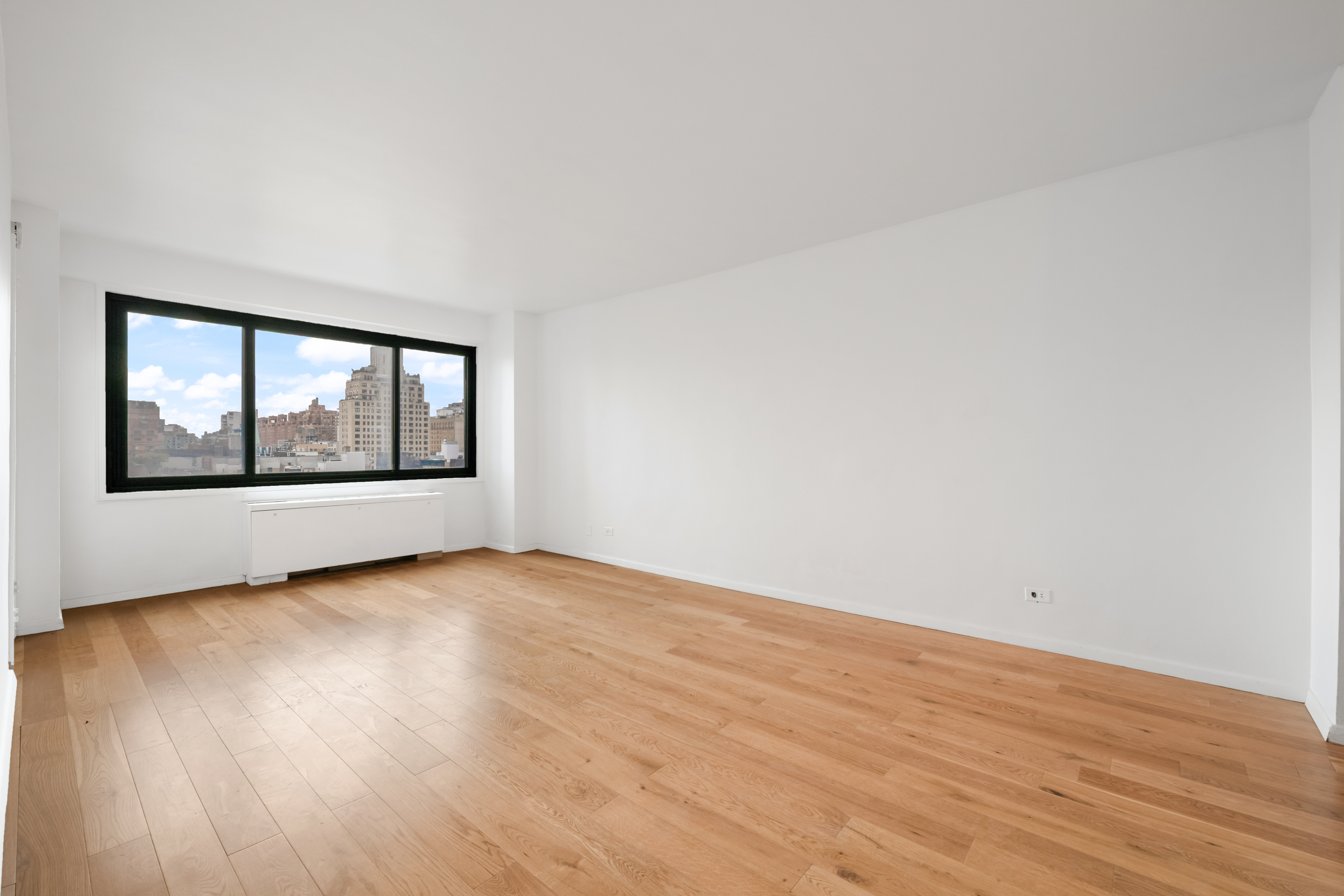 201 West 21st Street, Unit 9A Manhattan, NY 10011 - Photo 2 of 13 a view of an empty room with wooden floor and a window
