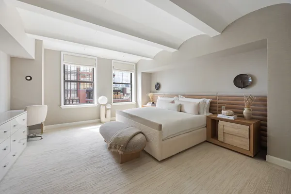 a bedroom with a large bed and flat screen tv