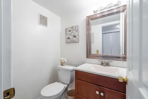 a bathroom with a sink mirror and toilet