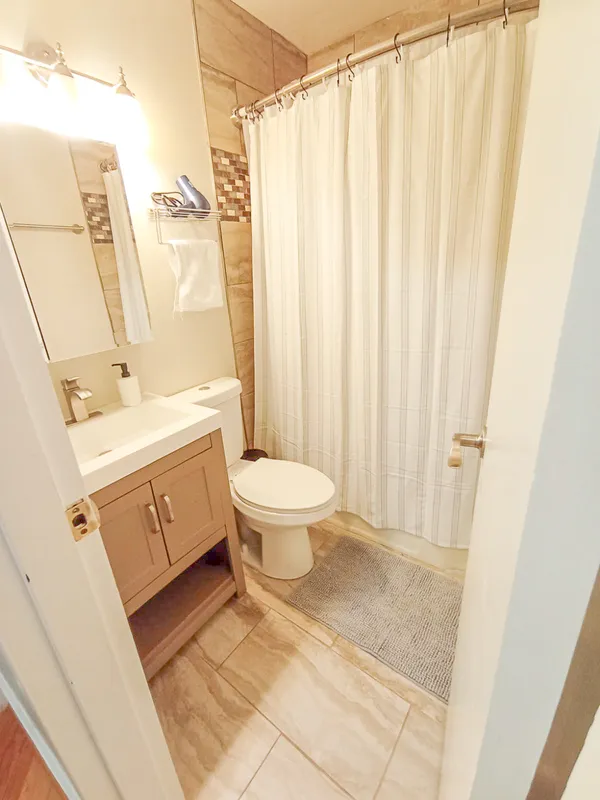 a bathroom with a sink a toilet and shower curtain