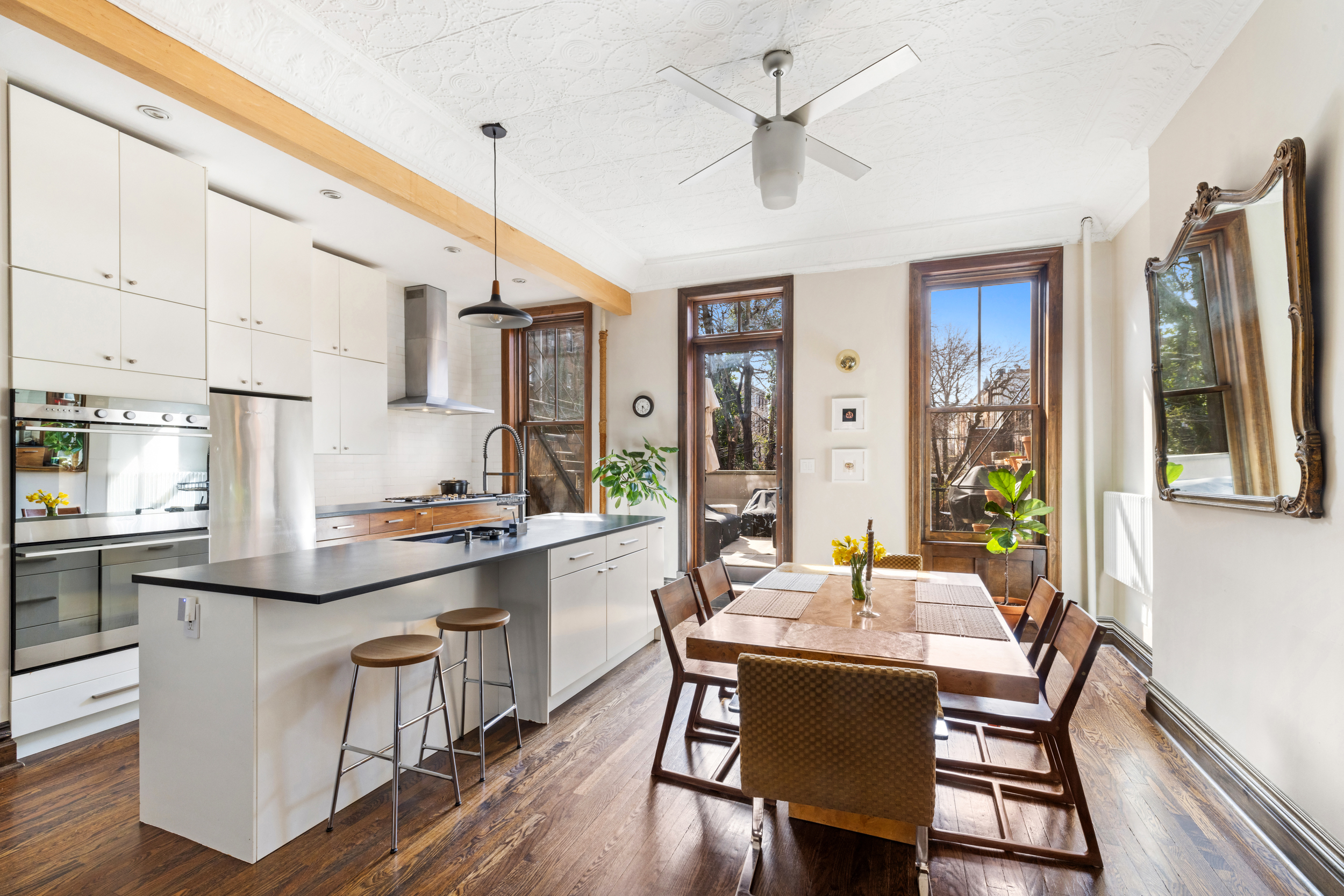 a kitchen with kitchen island a dining table chairs stainless steel appliances and cabinets