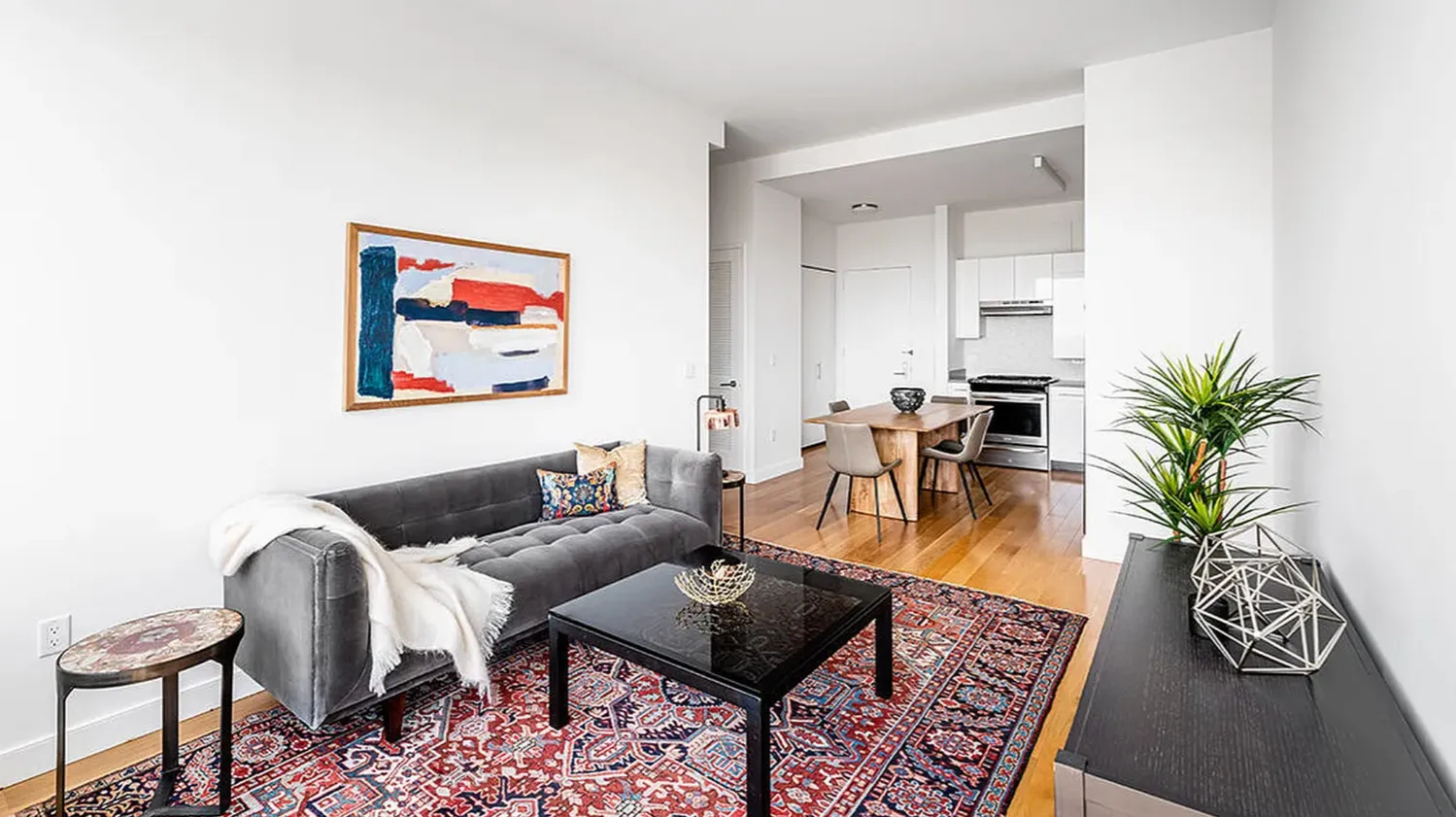 a living room with furniture and a table with wooden floor
