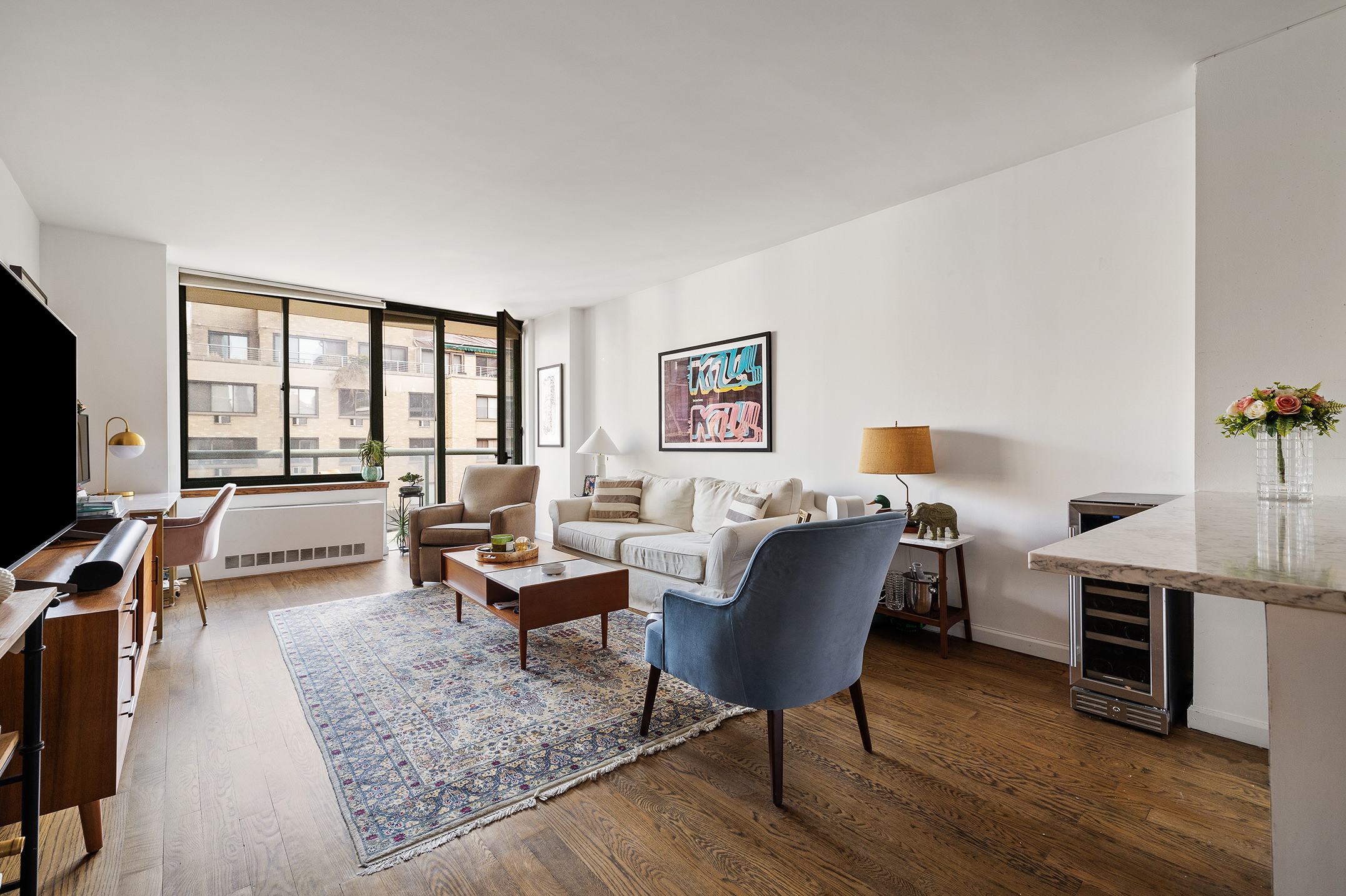 22 West 15th Street, Unit 10G Manhattan, NY 10011 - Photo 1 of 11 a living room with furniture a desk and chair with wooden floor