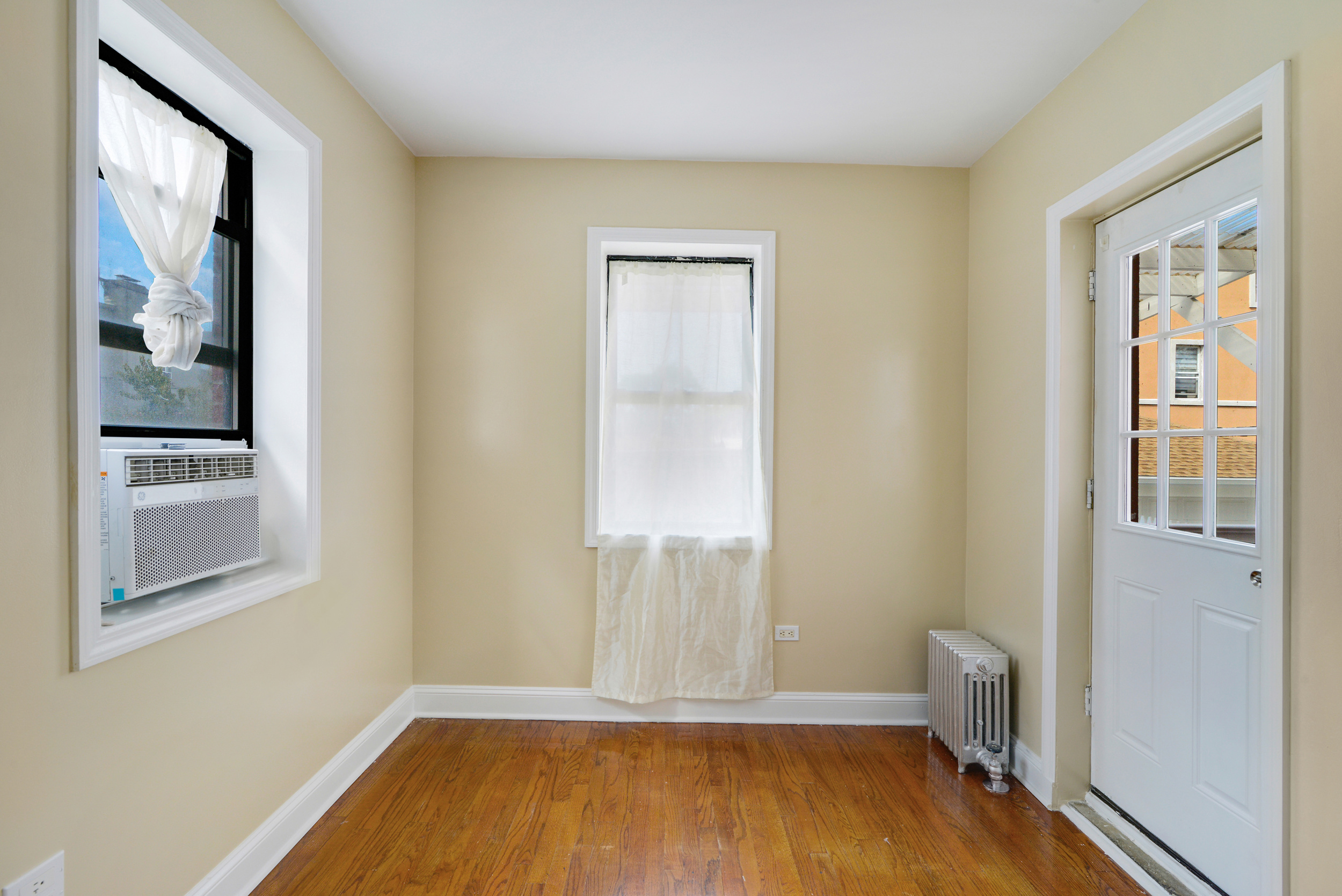 91-11 32nd Avenue, Unit 2 Queens, NY 11369 - Photo 6 of 9 a view of a room with wooden floor and a window