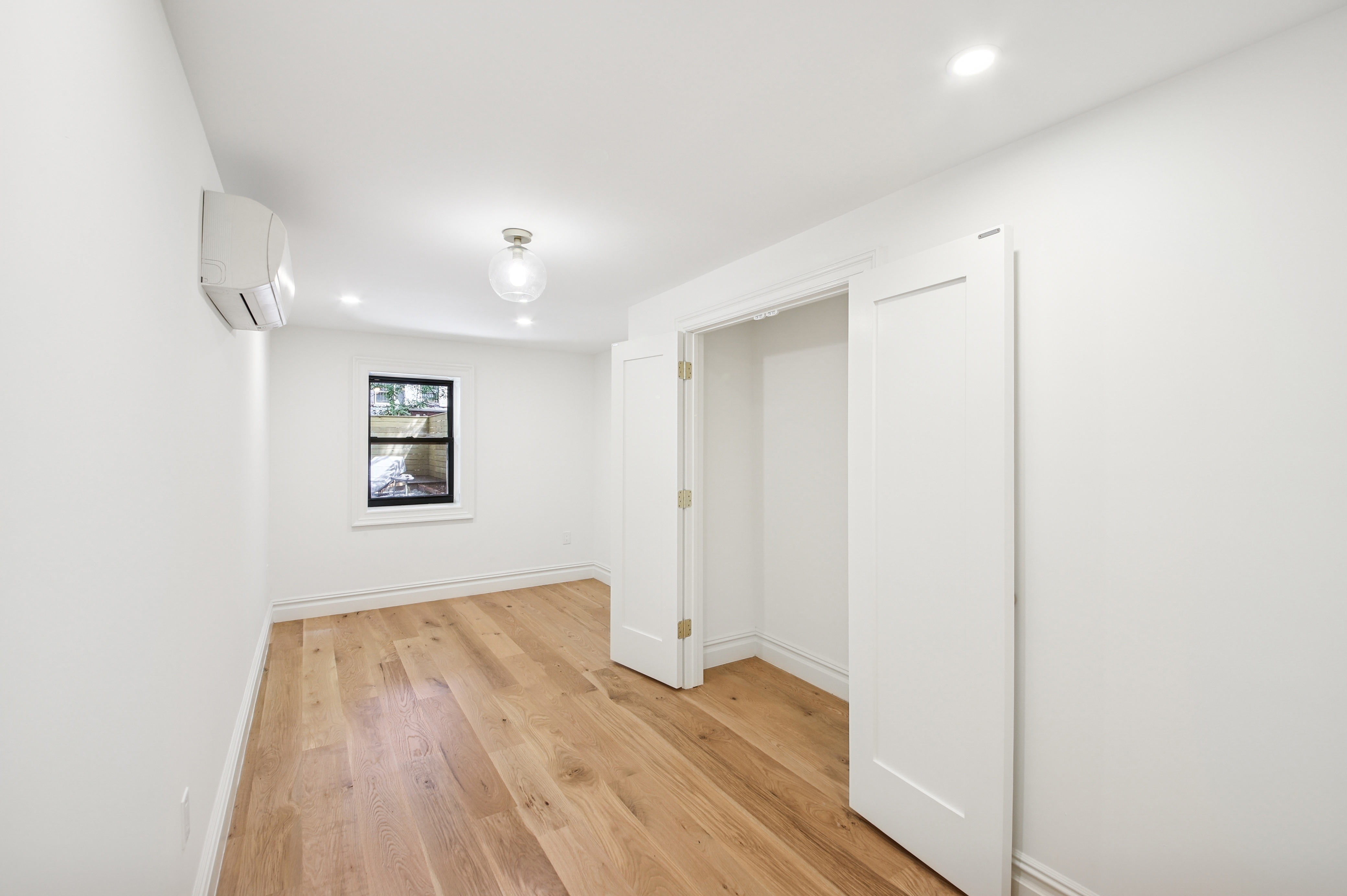 239 Madison Street, Unit 1 Brooklyn, NY 11216 - Photo 4 of 14 a view of a room with wooden floor and white doors