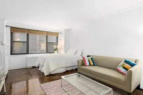 a bedroom with a bed couch and a window