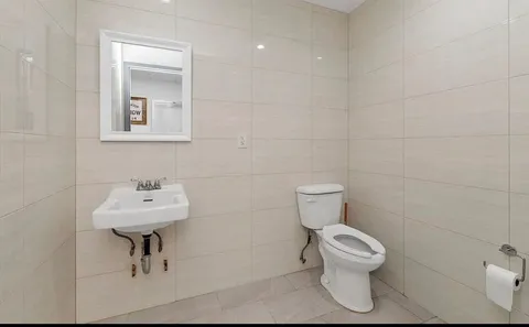 a bathroom with a toilet sink and mirror