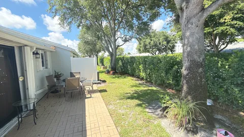 a view of a patio with couches table and chairs and potted plants