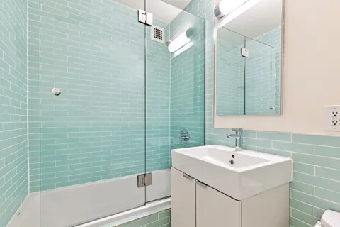 a bathroom with a sink a mirror and shower